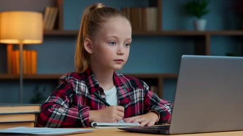 Girl Studies with Laptop and Writes in Notebook