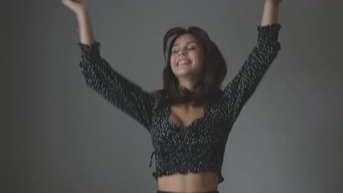 Excited Young Woman Jumping in Celebration Indoors