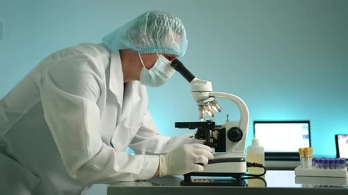 Male Medical Worker Researches Sample on Microscope in Laboratory in Vet Clinic