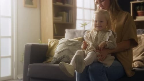 Woman and Child Sitting on Sofa Indoors