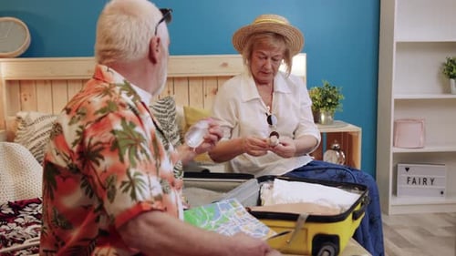 Senior Couple Packing Suitcase for a Vacation Together