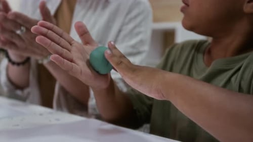 Child and Adult Shaping Modeling Clay Together