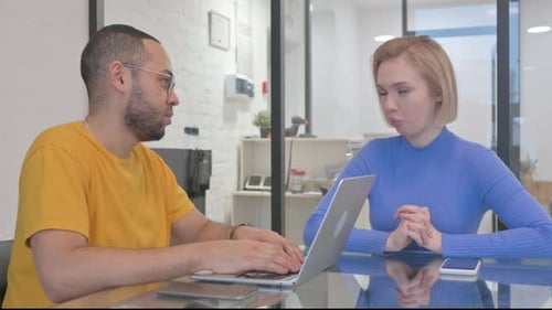 Man and Woman Collaborating on Laptop Computer
