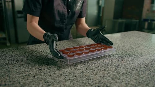 Gloved Hand Shaping Chocolate in Mold