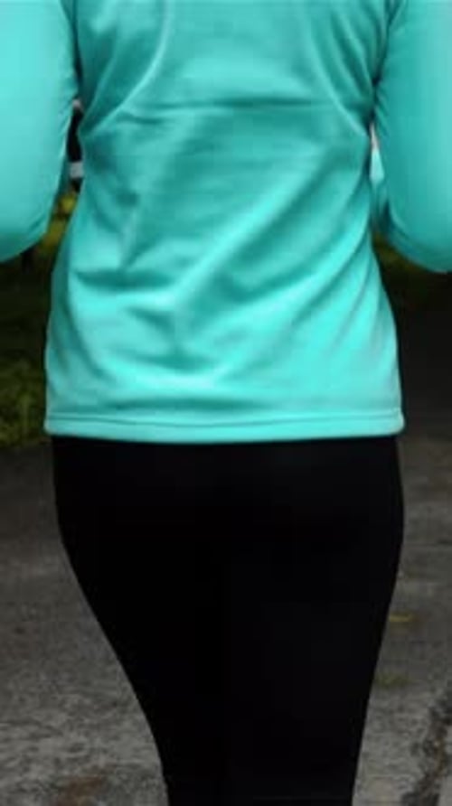 Vertical of Happy Sporty Woman in Smal Headphone Outdoors in Park