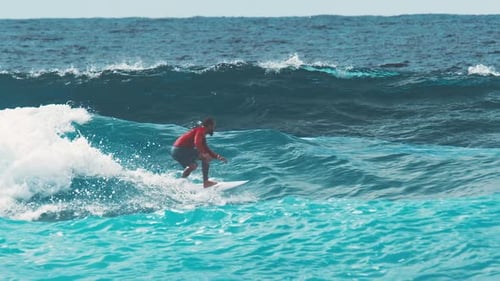 Surfer Rides the Wave in the Maldives