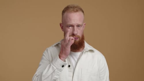 Junger Mann mit Bart verspricht, das Geheimnis zu bewahren