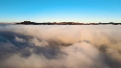 Aerial View of Landscape Above Foggy Fast Moving Clouds Covering Smoky Mountain Hills at Sunrise