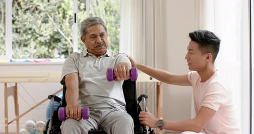 Senior Adult Exercising with Weights and Young Adult