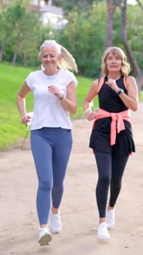 Senior Women Friends Jogging Together in a Park
