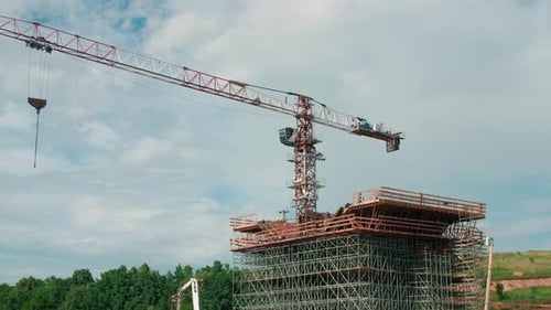 Grúa de torre con soporte de puente inacabado en obra