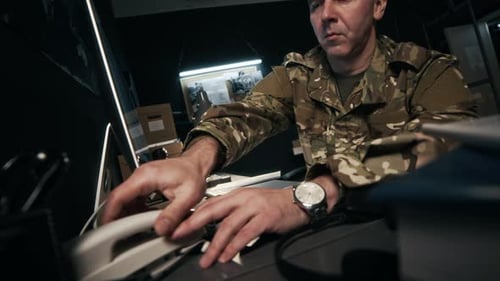 Soldier Answers Phone While Working at His Desk
