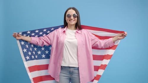 Woman Smiles Holding United States Flag in Studio