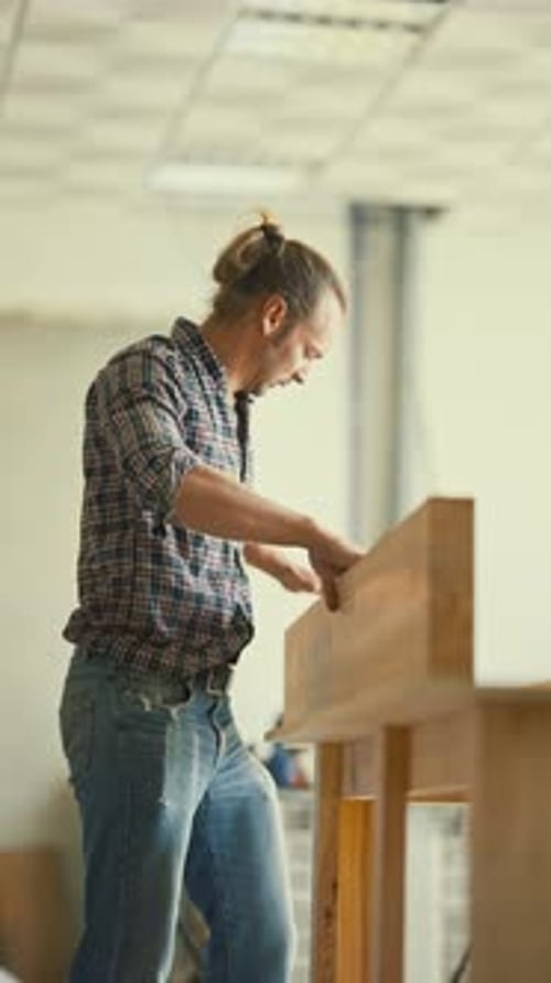 Skilled Carpenter Assembling Wooden Furniture in Workshop