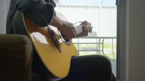 Guitarist Plays Music Near a Window