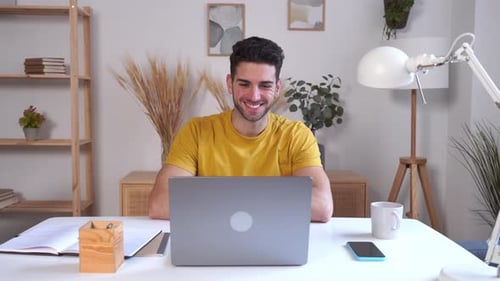 Man Chatting Online Using Laptop at Home