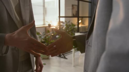 Close-up of Unrecognisable Coworkers Shaking Hands to Congratulate Each Other