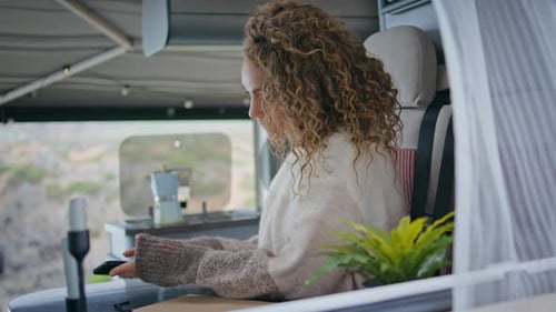 Woman Using Phone inside Camper Van
