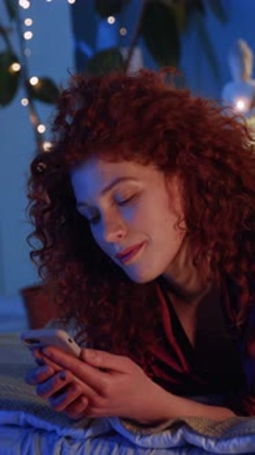 Woman with Red Hair Using Phone at Night