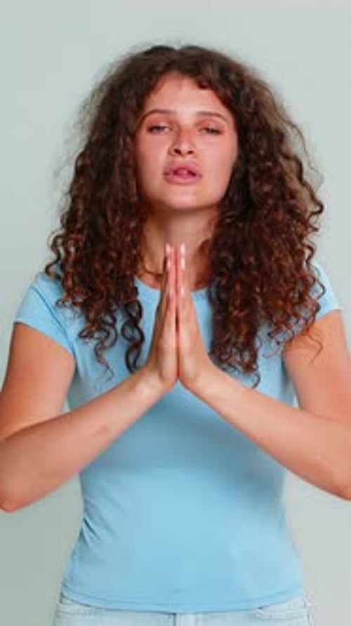 Young Woman with Curly Hair in Prayer Position