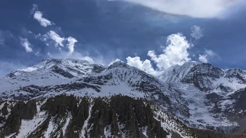 Day timelapse overlooking the Annapurna Mountain Range with clouds on a sunny day from Manang, Nepal