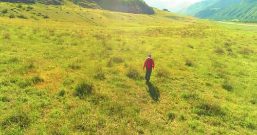 Flight Over Backpack Hiking Tourist Walking Across Green Mountain Field