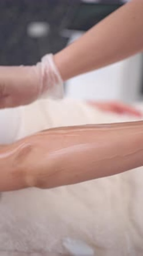 Wax being applied to a woman's arm