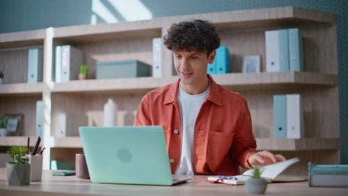 Young Man Working at Laptop in Office