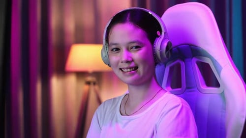 Young Woman Using Computer with Headphones at Night