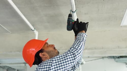 Indian Technician Installs Air Conditioning System at Office