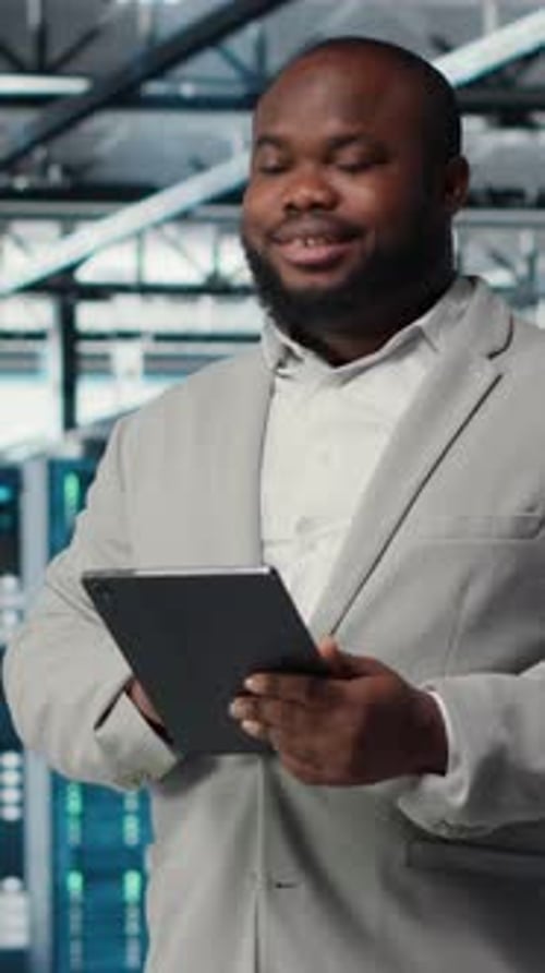 Vidéo verticale Un programmeur de centre de données joyeux regarde des outils de débogage de code sur une tablette