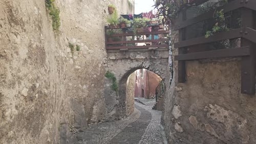 Historical Empty medieval cobble street with stone archway Malcesine