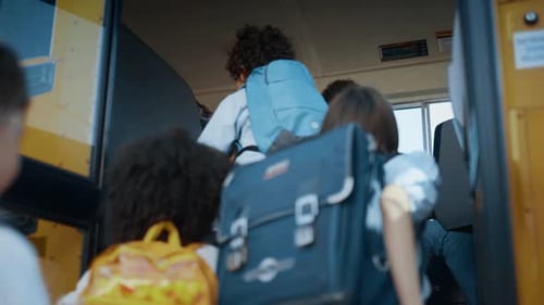 Energetic multi racial students board yellow schoolbus as driver watches
