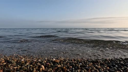 Sea Beach Horizon Sea Waves with Soft Foamy Waters Washing Multicolored Pebbles on a Beach During