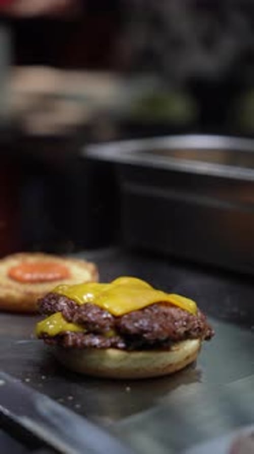 Chef Assembling Cheeseburger with Double Patty