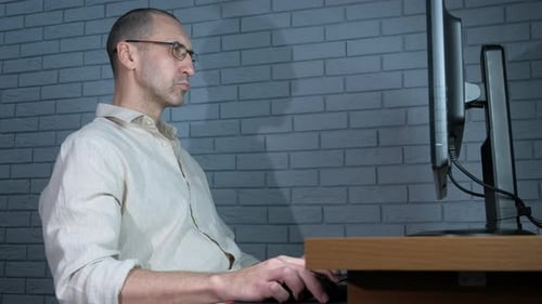 Einsamer freiberuflicher Mann, der spät drinnen arbeitet