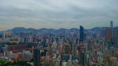 Drone shot ,traveling to the right, of a big city during a cloudy day with business buildings in the