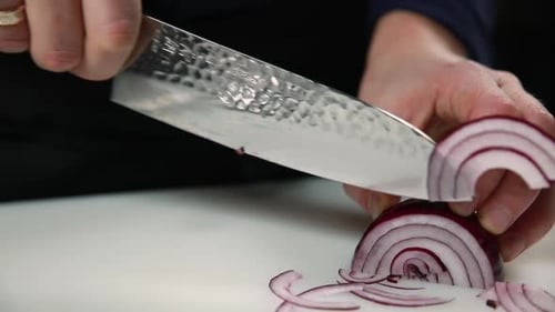 Slicing Red Onion on Cutting Board with Knife