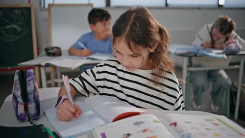 Students Studying in Classroom, Writing in Notebooks