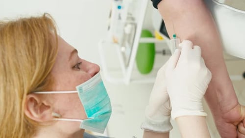 Closeup of a Female Doctor Setting Up a Blood Sampling System