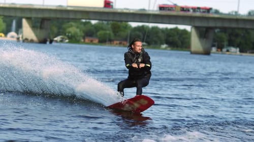 Man wakeboarding on river during bright day