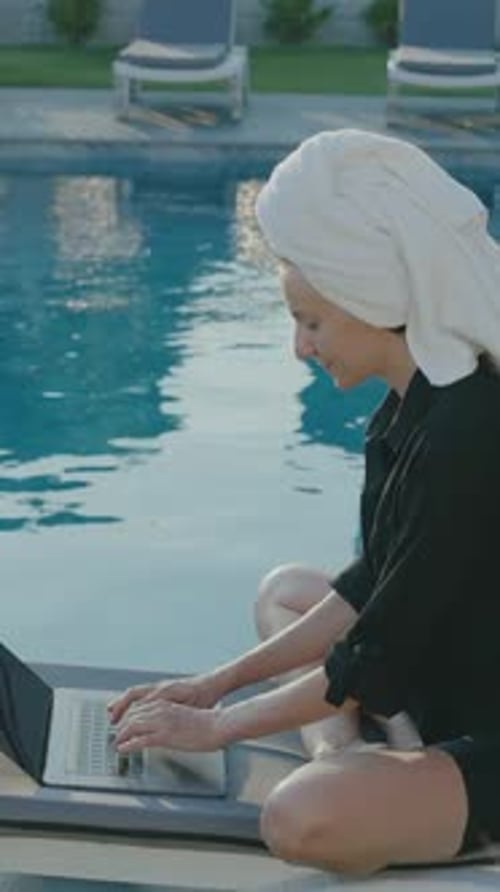 Woman Working on Laptop by Tropical Pool