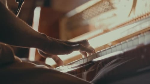 Hands Play Piano Keys in Golden Light
