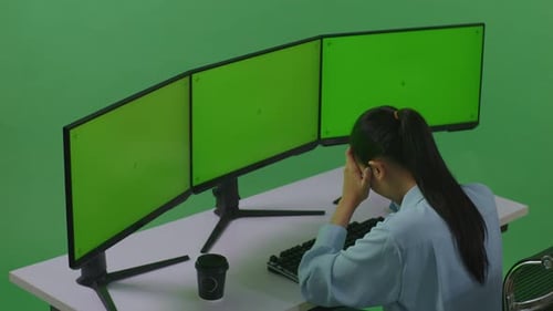 Asian Woman Having Headache While Working With Mock Up Multiple Computer Monitor In Green Screen