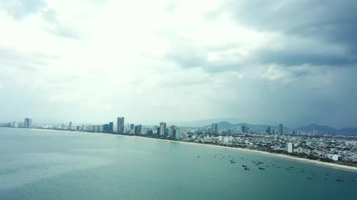City, sea and cloud on landscape with drone, storm or rain in winter with town