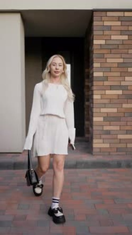 Stylish Woman Walks in White Outfit