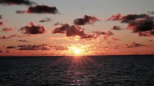 Magnifique lever de soleil avec des éruptions solaires sur l'océan, vu depuis un bateau en mouvement