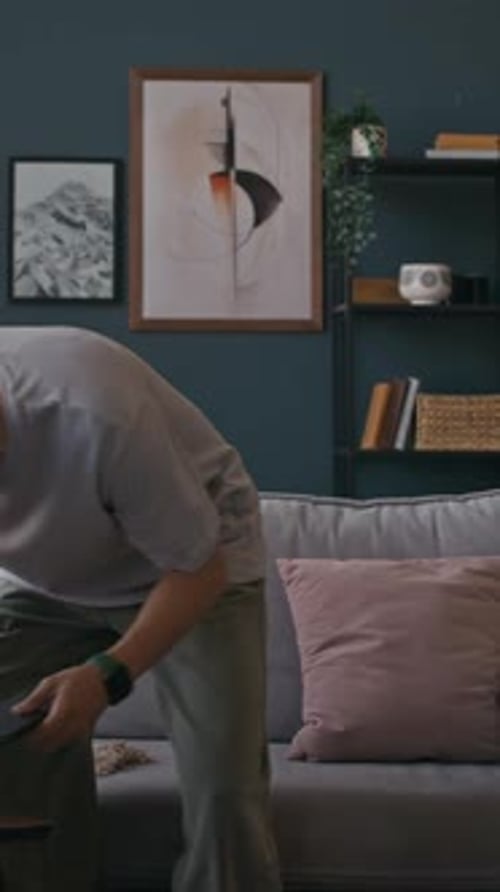 Freelancer Sitting down on Sofa Working on Laptop in Home Office