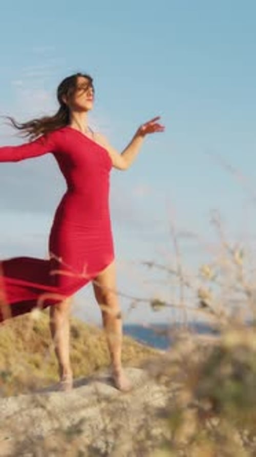 Woman in Red Dress Dancing on Cliff