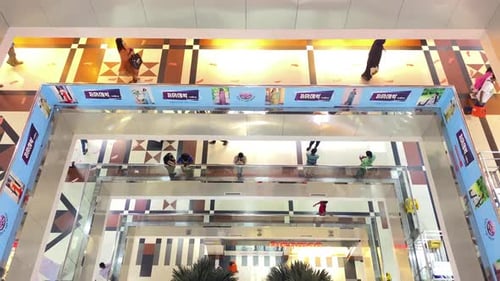 Looking down from the top of a shopping centre at multiple floors of shoppers.